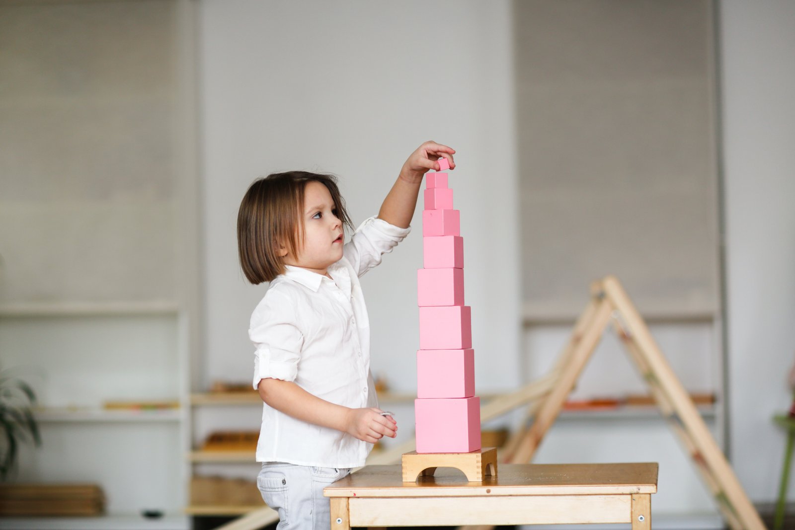 Child building with Montessori pink tower materials